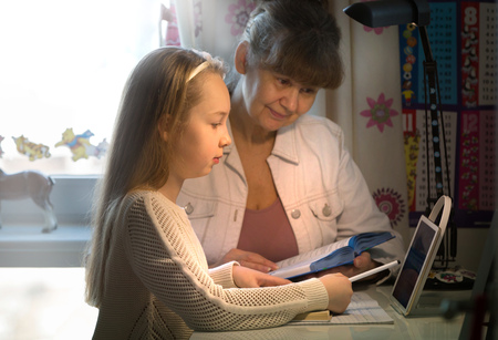 10 years old girl and her teacher. Little girl study during her private lesson. Tutorial and educational concept.の写真素材