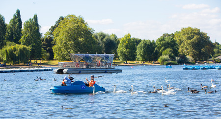 London, UK - September 8, 2016: Hyde Park featuring the Serpentine recreational lake and people having fun with pedalling boatsのeditorial素材