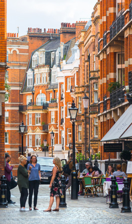 London, UK - September 8, 2016: Group of young people chatting next to the Cafe entrance at the Kensington hight street.のeditorial素材