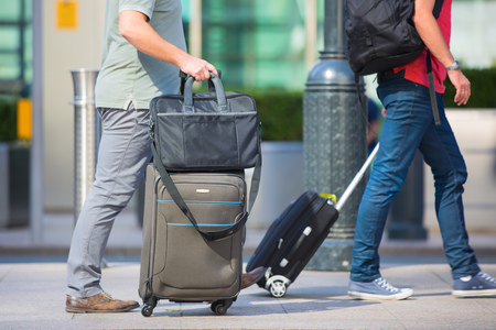 London, UK - 8 September, 2016: People with travel cases walking in the Canary Wharf financial aria. Modern life conceptの写真素材