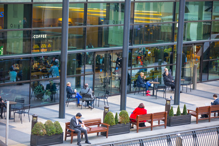 London, UK - March 15, 2017: Lunch time at canary Wharf, people in the cafe by the waterのeditorial素材