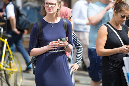 London, UK - August 24, 2016: Woman with mobile phone, Piccadilly circus junction.