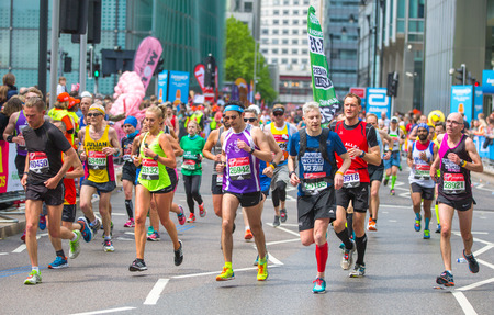 London, UK - April 23, 2017: Lots of people running in London Marathon. People cheering the sportsmen in Canary Wharf areaのeditorial素材