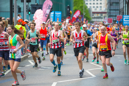 London, UK - April 23, 2017: Lots of people running in London Marathon. People cheering the sportsmen in Canary Wharf areaのeditorial素材