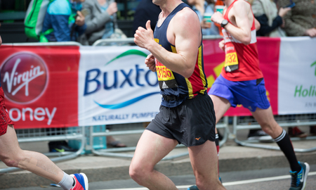 London, UK - April 23, 2017: Close up body of London Marathon runners. People cheering the sportsmen in Canary Wharf ariaのeditorial素材
