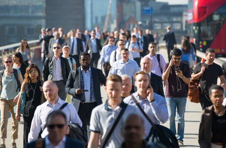 London, UK - April 19, 2018: Blurred image of office workers crossing the London bridge in early morning on the way to the City of London, the leading business and financial area in Europe. Rush hoursのeditorial素材
