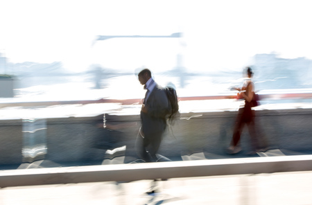 London, UK. Blurred image of office workers crossing the London bridge in early morning on the way to the City of London. Tower bridge at the background. Rush hoursの写真素材