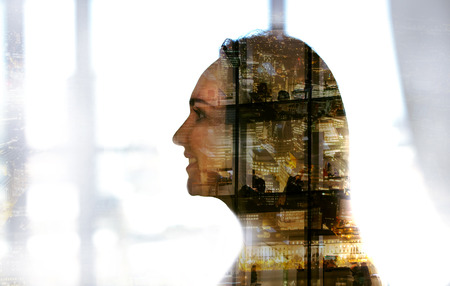 Young woman portrait with multiple exposure effect of London's office windows at evening.の写真素材