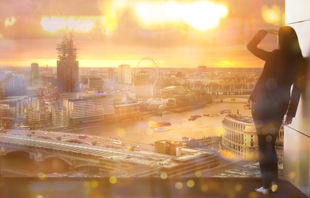 Young woman looking over the City of London at sun setのeditorial素材