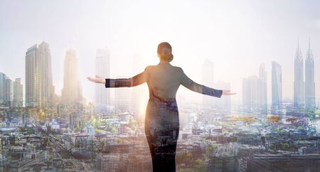 Business woman looking at the modern skyscrapers and sunset. Global business,  success and strategy conceptの写真素材