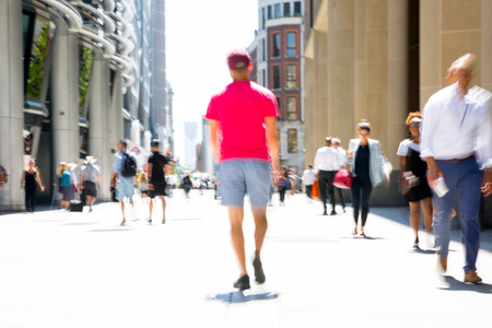 LONDON, UK - 26 June, 2018: Young man walking in the City against of sun light in hot summer day. Beautifully lit up street by the sun, City of London modern busy concept.のeditorial素材