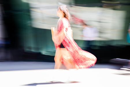 LONDON, UK - 26 June, 2018: Young woman walking in the City against of sun light in hot summer day. Beautifully lit up street by the sun, City of London modern busy concept.のeditorial素材