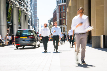 LONDON, UK - 26 June, 2018: Group of people walking in the City against of sun light in hot summer day. Beautifully lit up street by the sun, City of London modern busy concept. Wide panoramic viewのeditorial素材
