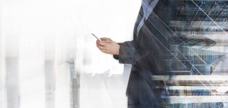 Young business woman in suit searching/texting on mobile phone. Business concept image, developing, support, global communication.の写真素材
