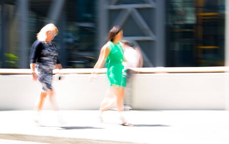 Silhouettes, abstract blurred image of business people walking in the City of London in sunny summer day. London, UKの写真素材