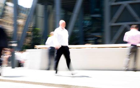Silhouettes, abstract blurred image of business people walking in the City of London in sunny summer day. London, UKの写真素材