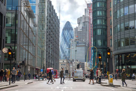 London, UK - 25 April, 2019: City of London busy street with view at the Gherkin building at the background, lots of people crossing the road, cars and busesのeditorial素材