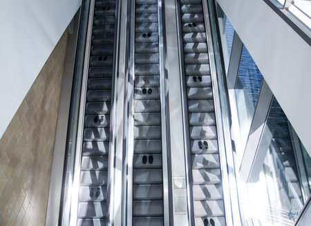 London, UK - 29 May, 2020: Empty escalators of office building tunnel in  Canary Wharf City of...