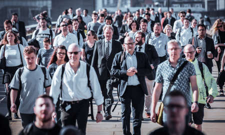 London, UK - 20 April, 2019: Lots of commuters, office workers crossing the London bridge on the way to City of London financial and office area.のeditorial素材