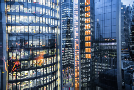 London, UK - 26 April, 2020: City of London windows of office  buildings with lights.