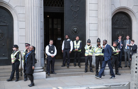 London, UK - April 25, 2019: Police officers and security stand by the Bank of England entrance door...