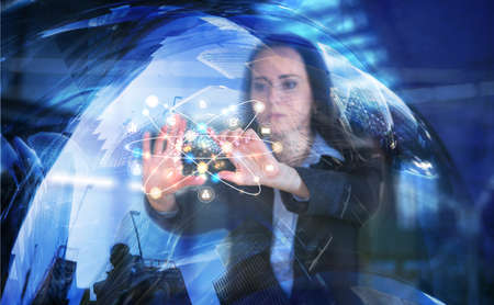 Business woman works with financial graphs on the virtual screen. Modern technology and digital layer effect shows business strategy.  Trade, success, control concept.の写真素材