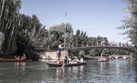 Cambridge, UK - July 16, 2021: River Cam and Punting boat with tourists relaxing and enjoying the views of Cambridge university's collegesのeditorial素材