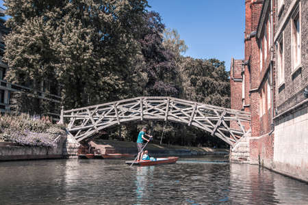 Cambridge, UK - July 16, 2021: River Cam and Punting boat with tourists relaxing and enjoying the views of Cambridge university's collegesのeditorial素材