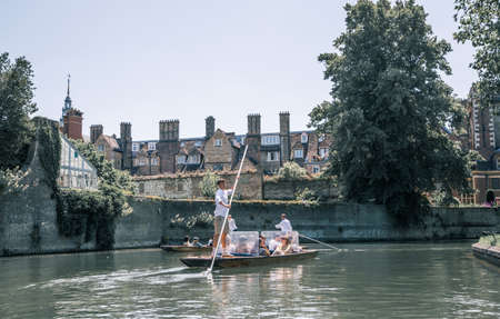 Cambridge, UK - July 16, 2021: River Cam and Punting boat with tourists relaxing and enjoying the views of Cambridge university's collegesのeditorial素材