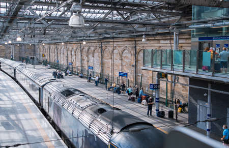Scotland, Edinburg - August 23, 2021: Edinburg central train station. People waiting boarding at the platformのeditorial素材