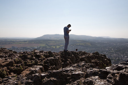 Scotland, Edinburgh, UK - August 26, 2021: Holyrood park and ancient volcano. People climbing on top...