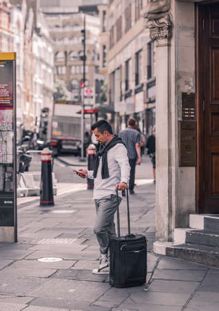 London, UK - June 21, 2022: Young man waiting someone in the City of London. Commuters, office workers, City of London life, Street photographyのeditorial素材