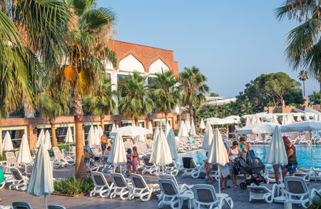 Turkey, Antalya, Lara beach - July 9, 2022:  Lots of sun beds by the pool in Lara beach Topkapi palace hotel. People relaxing by the poolのeditorial素材