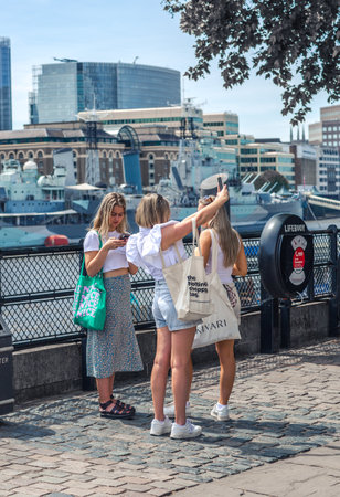 London, UK - 21 June, 2022: Family  waking on the Thames river walk at summer sunny day.  Street photographyのeditorial素材