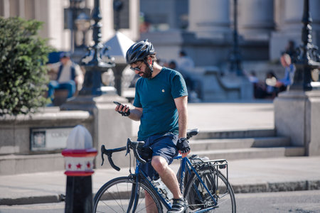 London, UK - June 22, 2022: Young man cycling at work by bike and make a spot by the traffic lights. People cycling into the City of Londonのeditorial素材