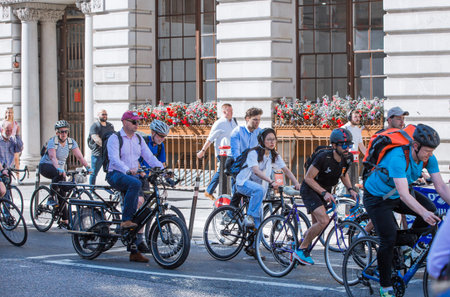 London, UK - June 22, 2022: People cycling at work by bike and stopped by the traffic lights. People cycling into the City of Londonのeditorial素材