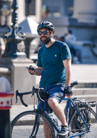 London, UK - June 22, 2022: Young man cycling at work by bike and make a spot by the traffic lights. People cycling into the City of Londonのeditorial素材