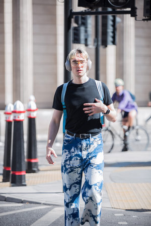 London, UK - June 22, 2022: Young man rush at work in early morning in the City of London. Business...
