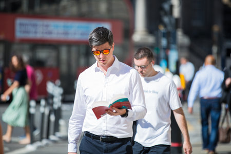 London, UK - June 22, 2022: Businessman is walking in early morning by the Bank of England. Busy business life of the City. People rush at work  street photographyのeditorial素材