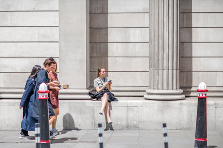 London, UK - June 22, 2022: People walking in early morning by the Bank of England. Busy business life of the City. People rush at work  street photographyのeditorial素材