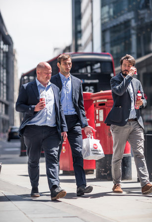 London, UK - June 22, 2022: Business people walking in early morning by the Bank of England. Busy business life of the City. People rush at work  street photographyのeditorial素材