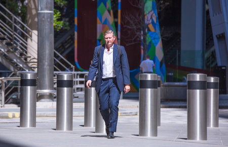 London, UK - June 22, 2022: Businessman is walking in early morning by the Bank of England. Busy business life of the City. People rush at work  street photographyのeditorial素材