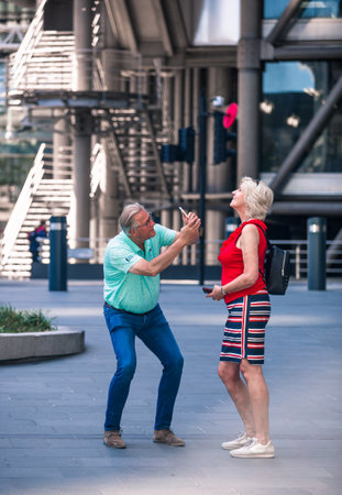 London, UK - June 22, 2022: Couple makes photography in the City of London. Romantic couple, tourists having fun in Londonのeditorial素材