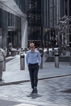 London, UK - June 22, 2022: Businessman is walking in early morning by the Bank of England. Busy business life of the City. People rush at work  street photographyのeditorial素材