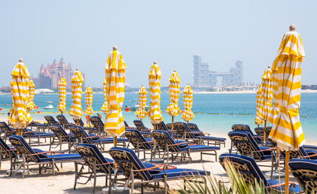 Dubai, United Arab Emirates - August 26, 2023:  White sand beach and Beas beds with umbrellas at Palm Jumeirahのeditorial素材