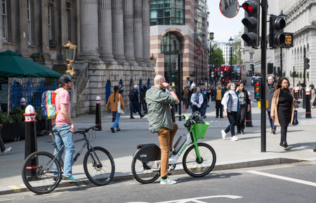 London, UK - 30 April, 2024: People commuting at work with bikes, City of London streetのeditorial素材