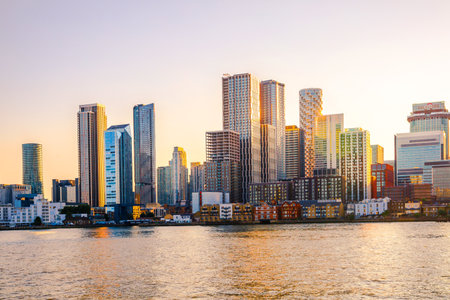 London, UK - 18 June, 2025: Canary Wharf business and banking area panoramic view from the river Thames at sunset golden hoursのeditorial素材