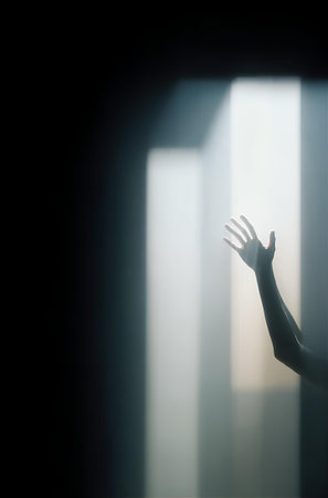 Silhouette of a woman's hand through the window with sunlightの素材