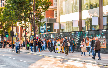 London, UK - October 12, 2025: Lots of people shopping in Oxford street at sunset. People walking from shop to shop