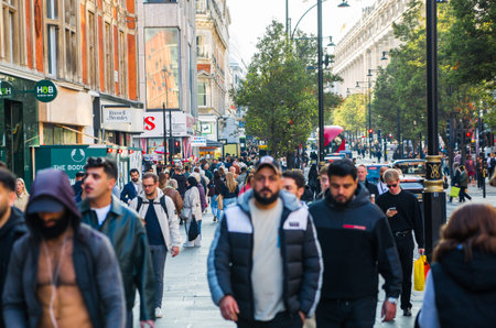 London, UK - October 12, 2025: Lots of people shopping in Oxford street at sunset. People walking from shop to shop